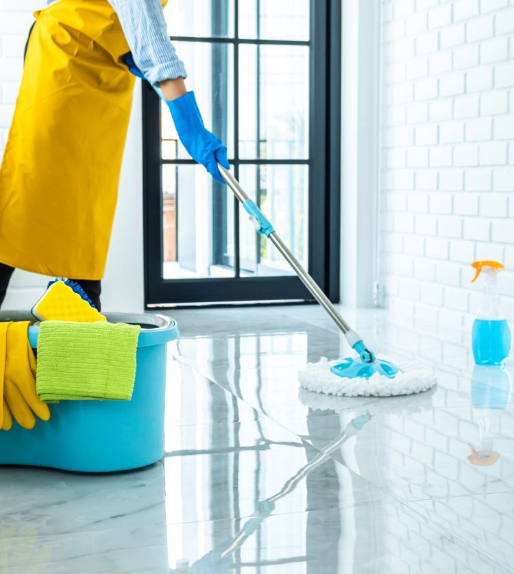 Wife housekeeping and cleaning concept, Happy young woman in blue rubber gloves wiping dust using mop while cleaning on floor at home.