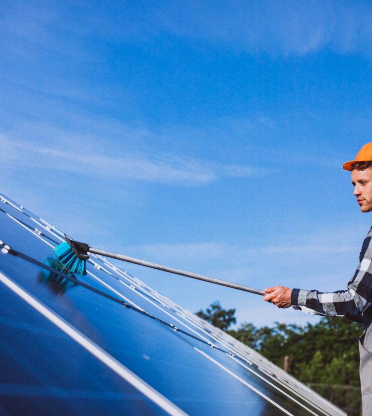 Man worker in the firld by the solar panels